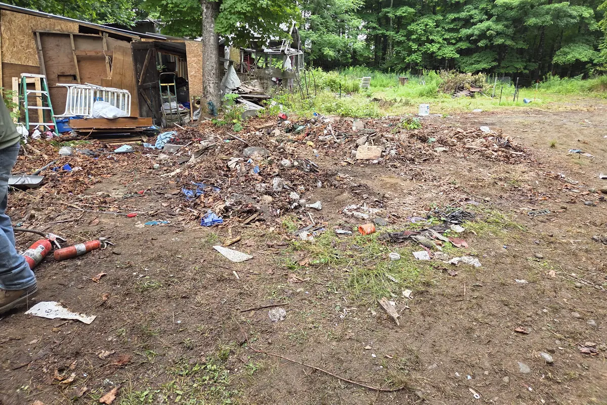 A collapsed plywood shed and scattered demolition debris part way through a Brute Waste teardown