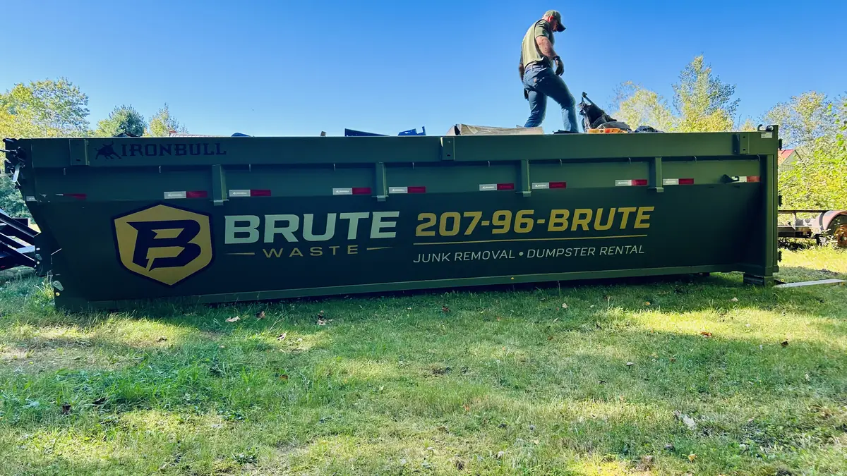 A loaded Brute Waste roll-off dumpster sheeted over and strapped down ready for the road